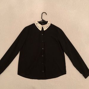 Black blouse with white lace collar.